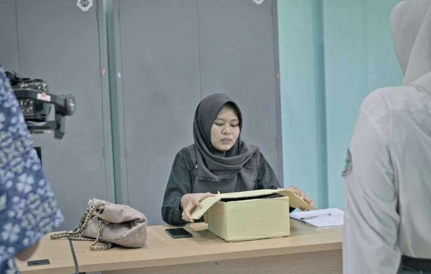 Woman in hijab at desk with papers