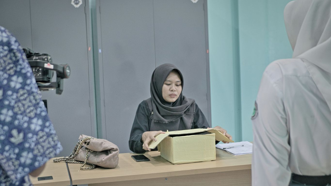 Woman in hijab at desk with papers