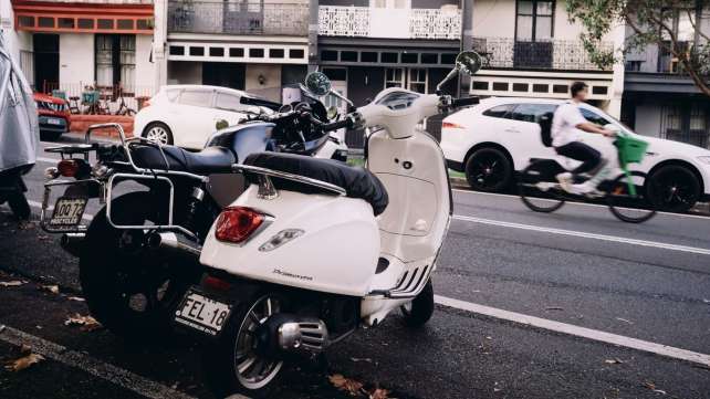 Motorbikes and scooters parked on a city street.