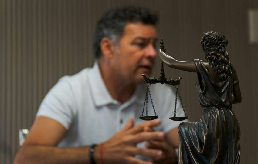 A man sitting at a table in front of a statue