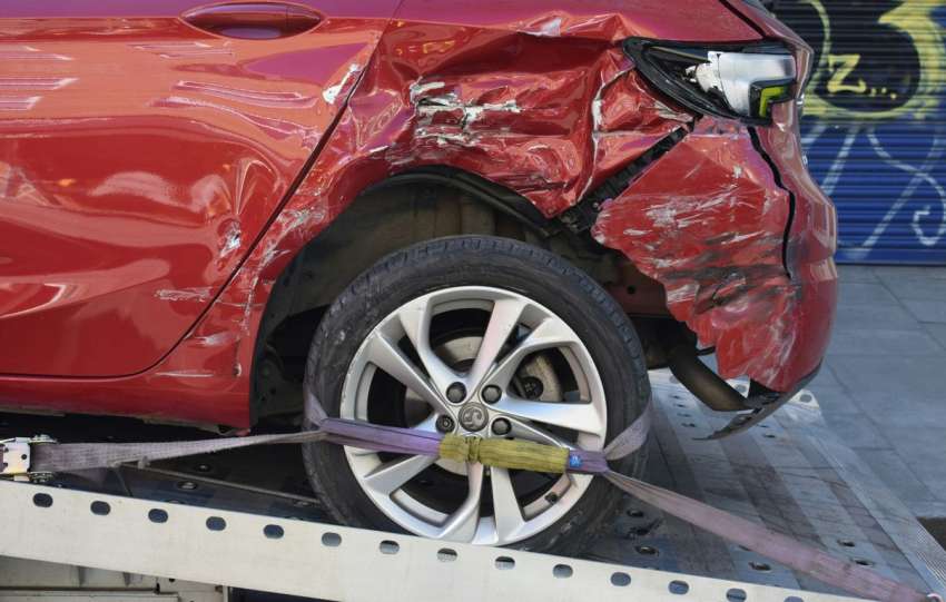 a red car is on a flatbed tow truck