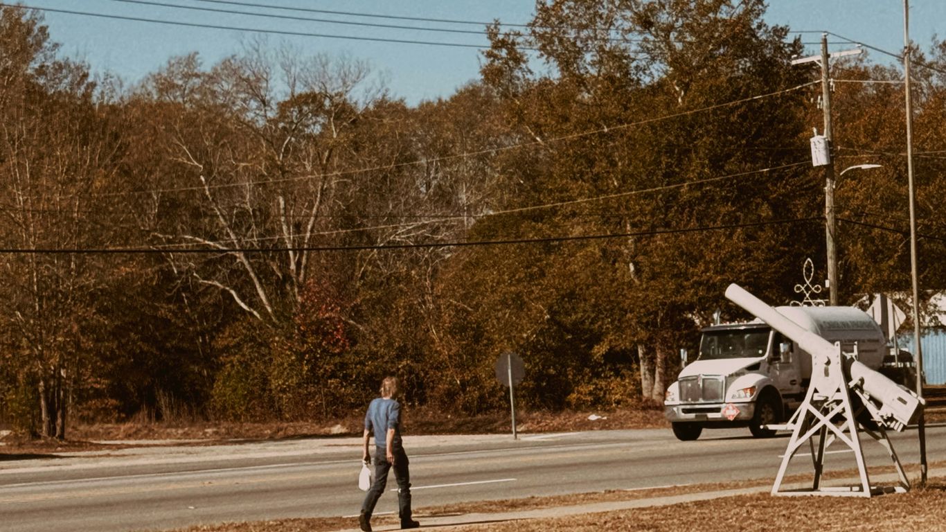 Man walks past a utility truck and equipment.