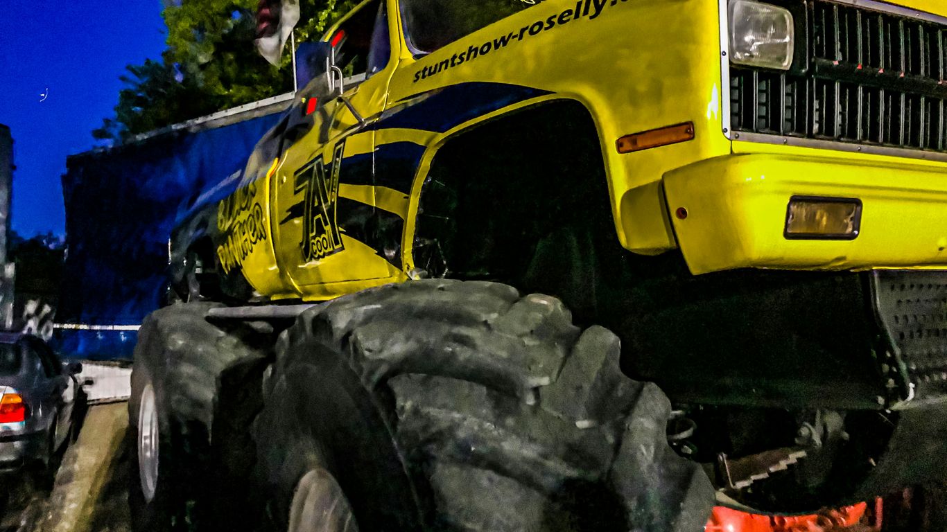 yellow and black tractor near green trees during daytime