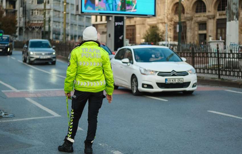 A person in a yellow jacket is standing on the street