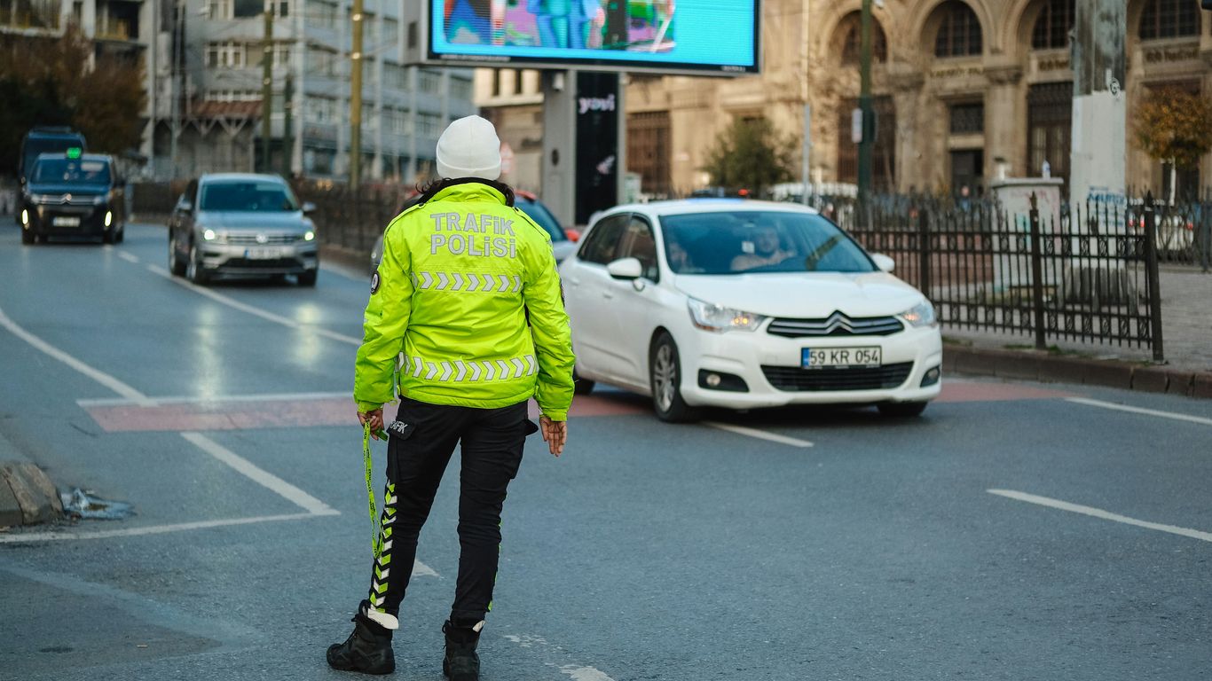 A person in a yellow jacket is standing on the street